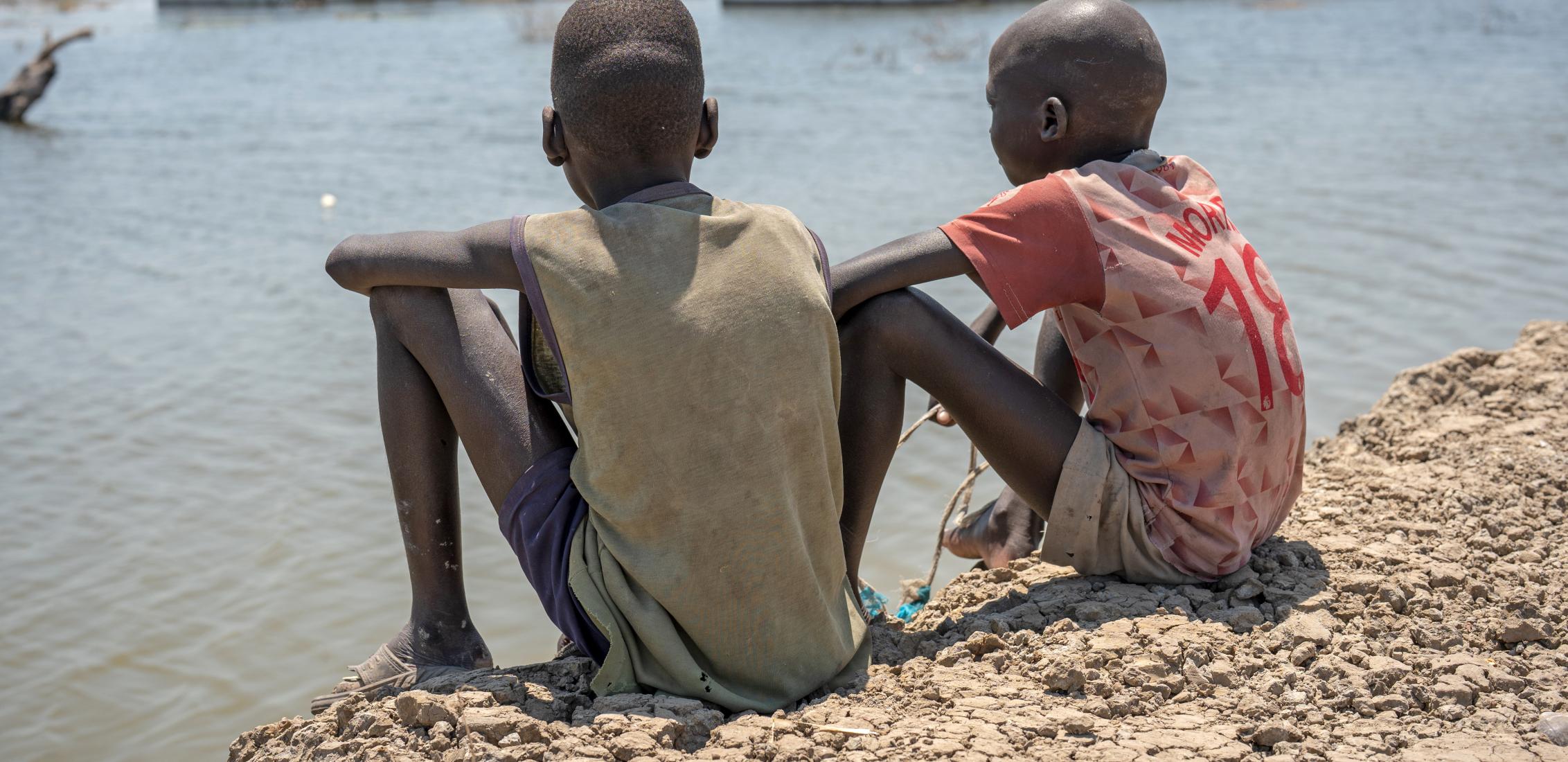 UNI424890/Naftalin On 4 March 2023, two boys look out over their flooded school in Bentiu, Unity State, South Sudan. Extensive flooding has affected thousands of people across Unity State with many having to flee their homes.