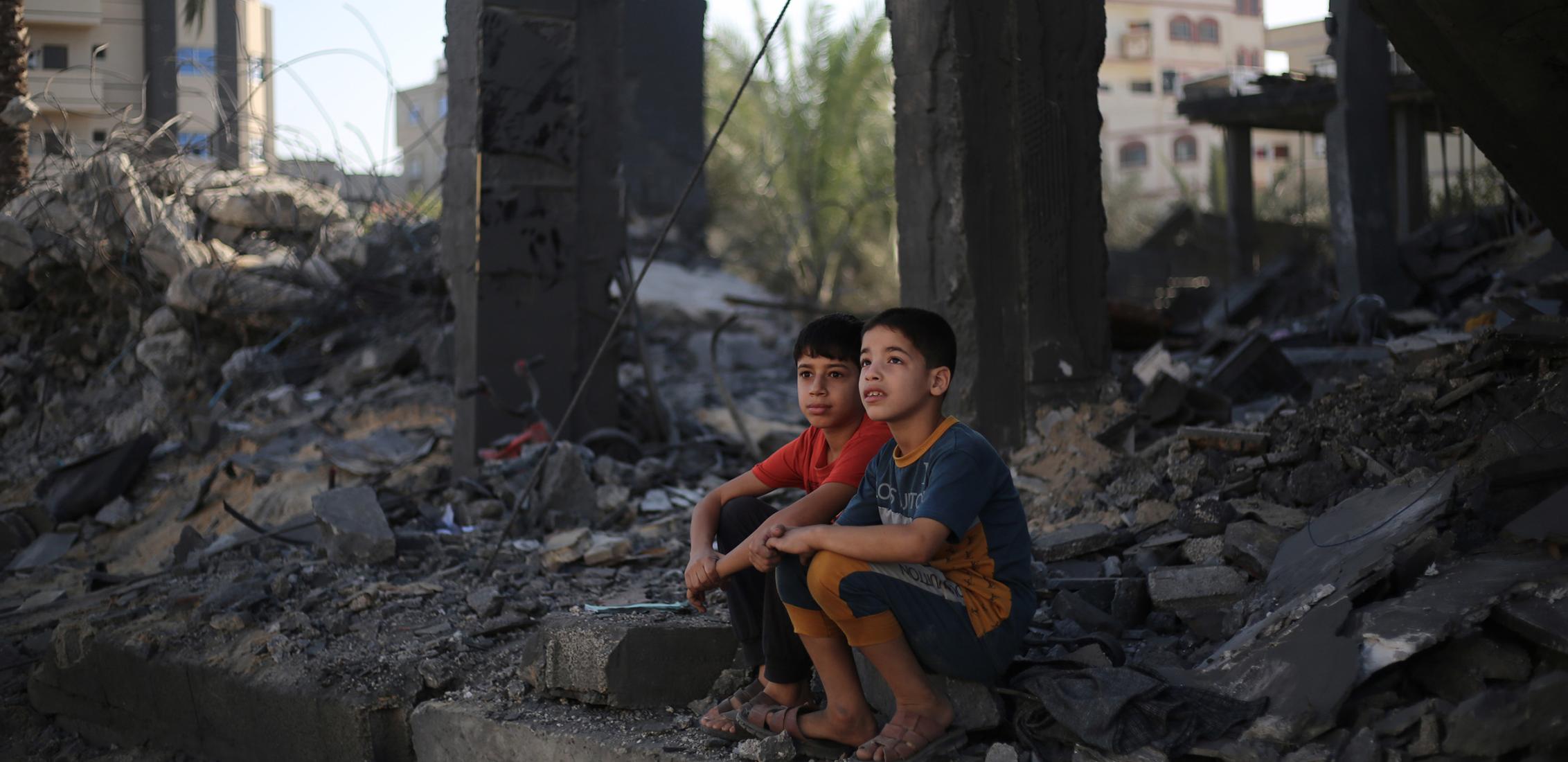 Deux enfants palestiniens assis dans les décombres de ce qui reste de leur maison dans la ville de Rafah, au sud de la bande de Gaza, en novembre 2023.
